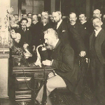 Alexander Graham Bell speaks into telephone