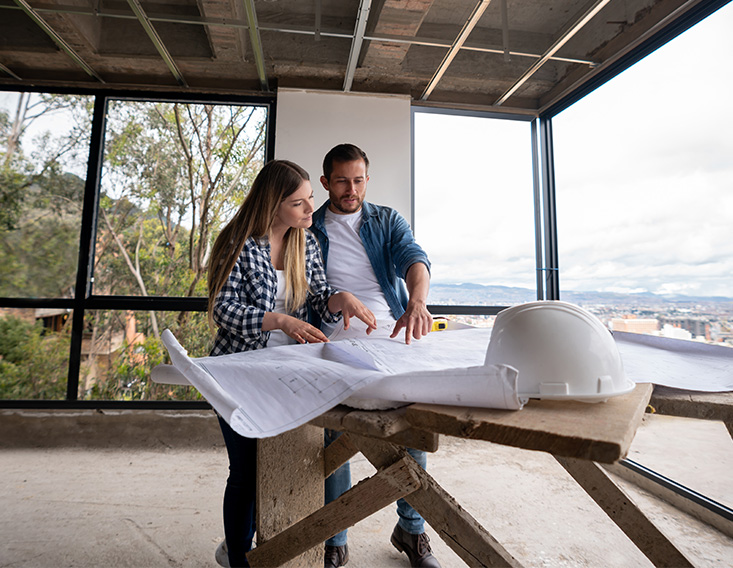 Couple looking at the plans for their new home financed by First State Bank Mortgage