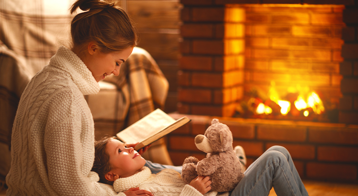 First State Bank CD special customer in front of her fireplace reading a book to her daughter.