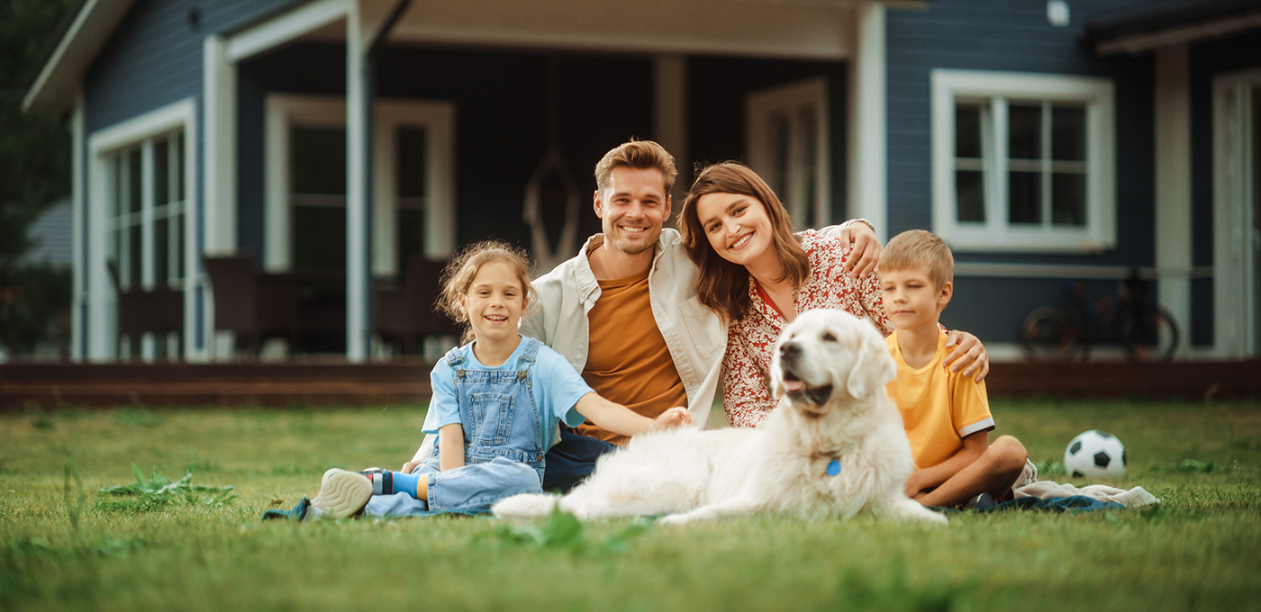 Family sitting in front of their new home financed by First State Bank Mortgage.