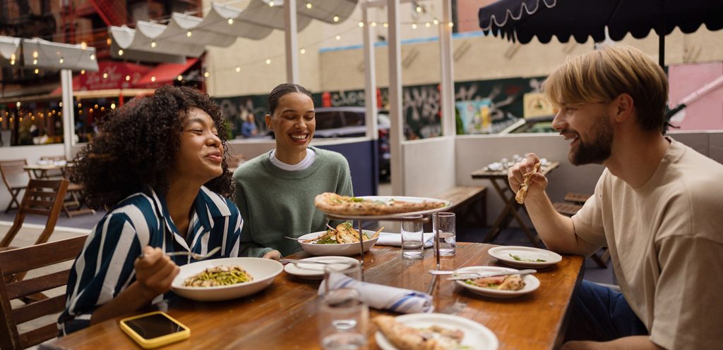 College students eat pizza together and split the bill using Zelle.