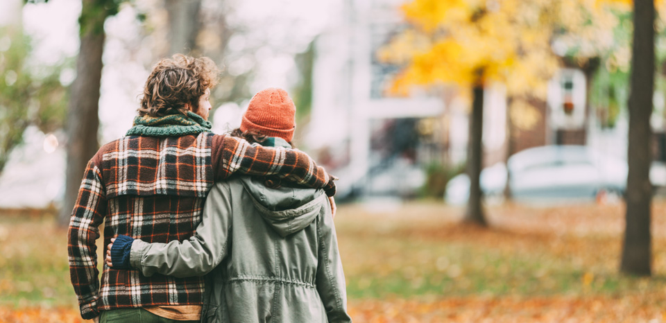 A couple walks neighborhood in fall while purchasing a new home.