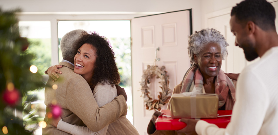 Couple arriving at a family home decorated for the holidays, a time when homeowners can consider home improvements